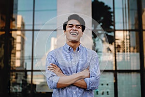 Portrait of Laughing Young Asian Businessman in the City. Crossed Arms and looking away. a Happy Man