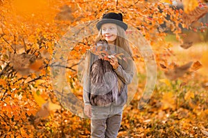 Portrait of a laughing young girl in the setting sun. Autumn portrait of a happy girl. Walk in the autumn park. Lifestyle