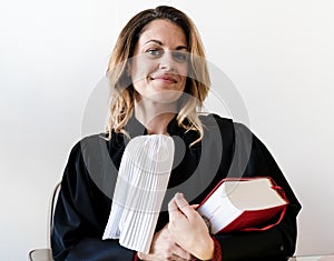 Portrait of lawyer woman standing and holding red law book