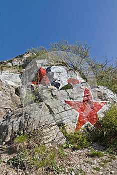 Portrait of Lenin and red star on a rock.