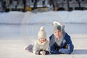 Portrait of little adorable girl and young father skating