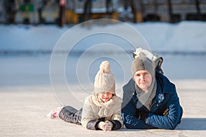 Portrait of little adorable girl and young father skating