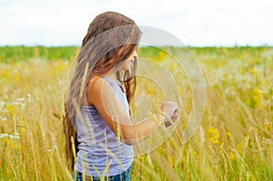 Portrait of a little adorable little girl smiling, in field with yellow flowers