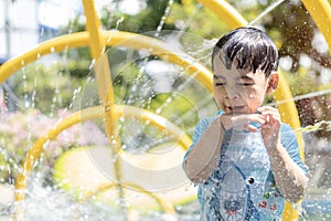 Portrait of little Asian cute boy enjoying day trip to an aqua amusement park during summer family vacation