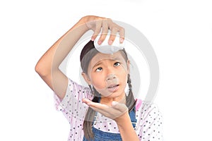 Portrait of little Asian girl holding piggy bank on white