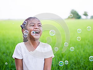 Portrait of a little asian girl is laughing and enjoy with bubbles.