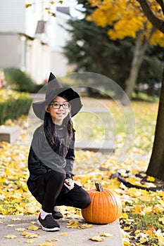 Portrait of little asian girl in witch costume