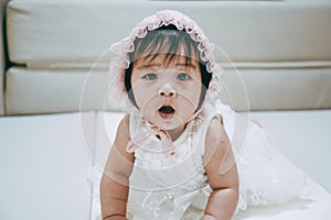 Portrait of Little baby girl wear white hood. Child with white theme suit.