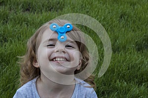 Portrait little beautiful girl is playing blue spinner.