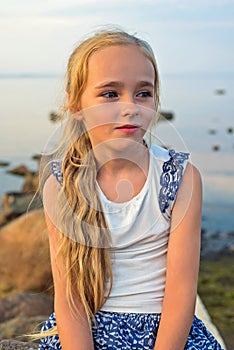 Portrait of little beautiful girl on sunset