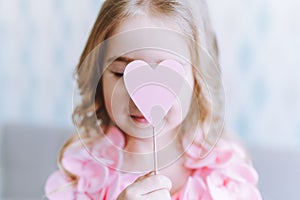 Retrato pequeno rubio posesión rosa de madera corazón antes su su ojos cerrado 