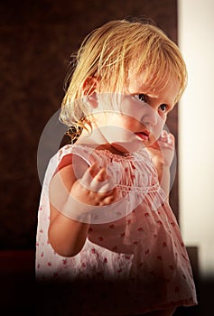 portrait of little blonde girl in pink under sunlight