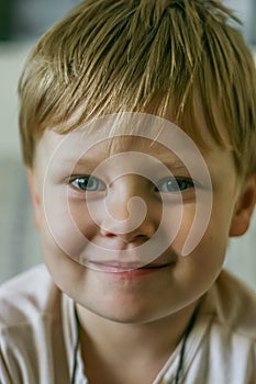 Portrait of a little blonde hair kid lokking at camera.