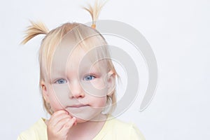 Portrait of a little blue-eyed blonde girl on a white background, close-up, looking at the camera, copy space, caucasian