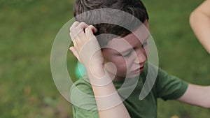 Portrait of little boy crying screaming on the grass in a park