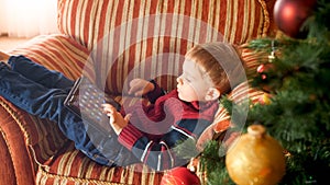 Portrait of little boy with digital tablet computer playing games or browsing internet. Child in house on Christmas