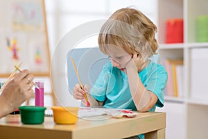 Portrait of little boy drawing something for art class