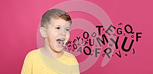 Portrait of little boy with letters on background. Speech therapy concept