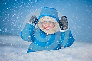 Retrato pequeno chico afuera en la nieve 