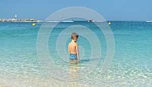 Portrait little boy playing in the sea, ocean. Happy family having fun on tropical white beach. Positive human emotions, feelings.