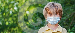 Portrait of a little boy in a protective mask on the street during coronavirus and Covid pandemic - 19. Boy wearing anti