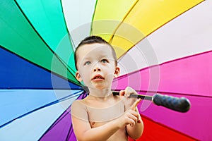 Portrait of the little boy with rainbow colors umbrella