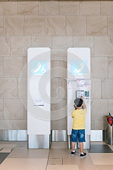 Portrait of a little boy using a payphone in an airport