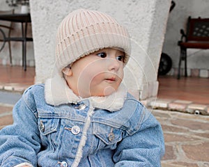 Portrait of a little boy in warm clothes, a denim jacket and a knitted hat