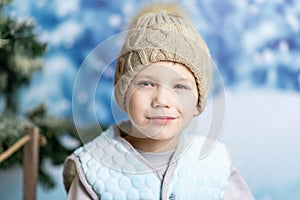 Portrait of a little boy in winter clothes on the background of winter