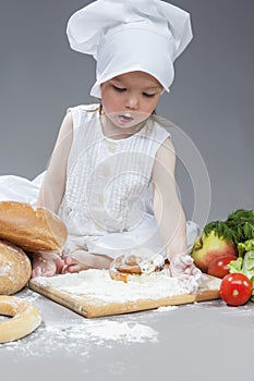 Portrait of Little Caucasian Girl in Cook Hat and Lips in Flour