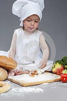 Portrait of Little Caucasian Girl in Cook Hat and Lips in Flour