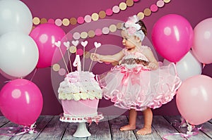 Portrait of a little cheerful birthday girl with the first cake. Eating the first cake. Smash cake