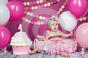 Portrait of a little cheerful birthday girl with the first cake. Eating the first cake. Smash cake