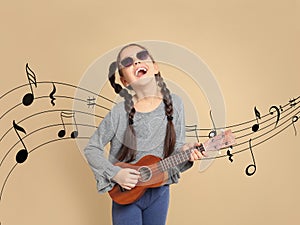 Portrait of little cheerful girl playing guitar