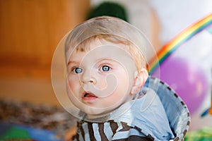 Portrait of little child, cute adorable baby boy playing with colorful toys. Happy, curious kid at home, indoors.