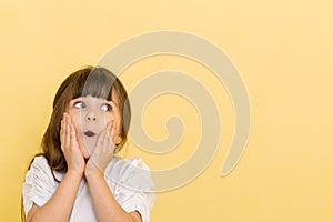 Portrait of little child girl holding hands on head, screaming with opened mouth and crazy expression