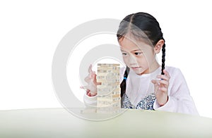 Portrait of little child girl playing wood blocks tower game for Brain and Physical development skill in a classroom. Focus at