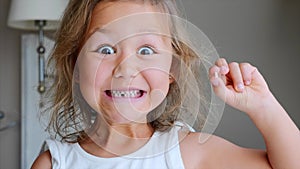 Portrait of little child girl is showing her lost milk tooth and smiling