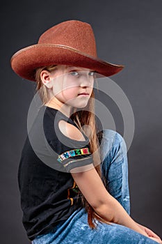 Portrait of little cool girl in a cowboy hat