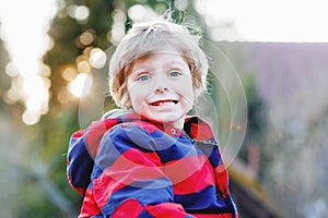 Portrait of little cool kid boy in forest. Happy healthy toddler child having fun on warm sunny day early spring. Family