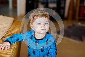 Portrait of little cute baby girl learning walking and standing. Adorable toddler girl at home. Beautiful baby child in