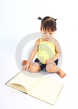 Portrait of little cute baby girl reading book.