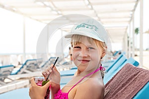 Portrait of little cute blond caucasian child girl enjoy having fun relax drinking mojito lemonade chilling at seaside