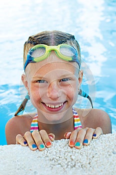 Portrait of little cute girl in the swimming pool.