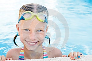 Portrait of little cute girl in the swimming pool.