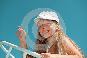 Portrait of little cute girl waving goodbye on a boat