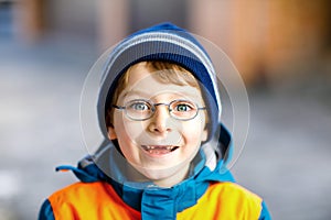 Portrait of little cute school kid boy with glasses