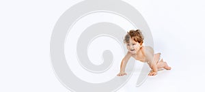 Portrait of little cute toddler boy, baby in diaper crawling isolated over white studio background. Flyer