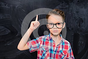 Portrait of little genious in glasses having great idea