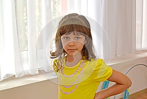 Portrait of the little girl against the background of a window i